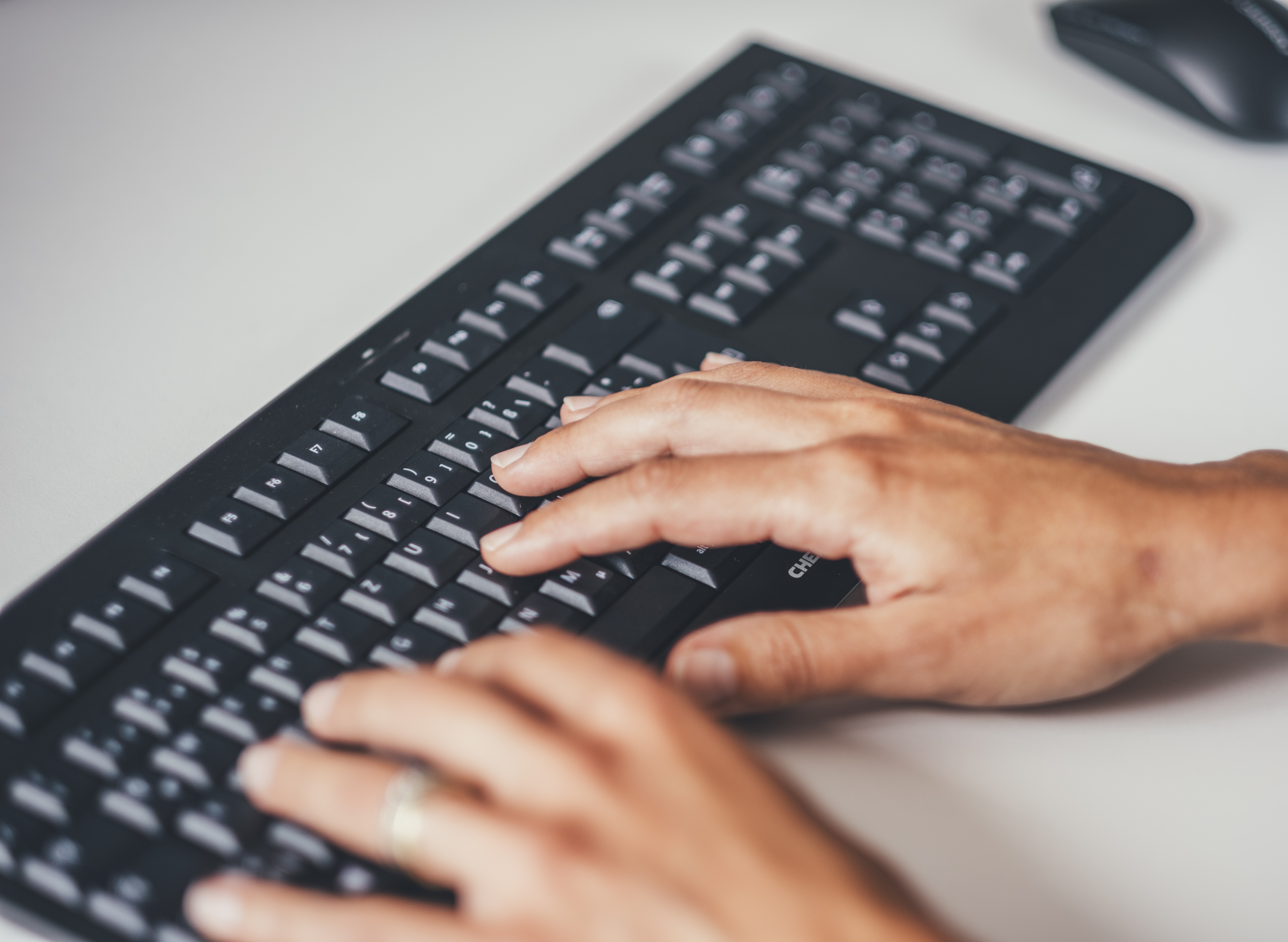 Hände liegen auf einer Computer Tastatur.
