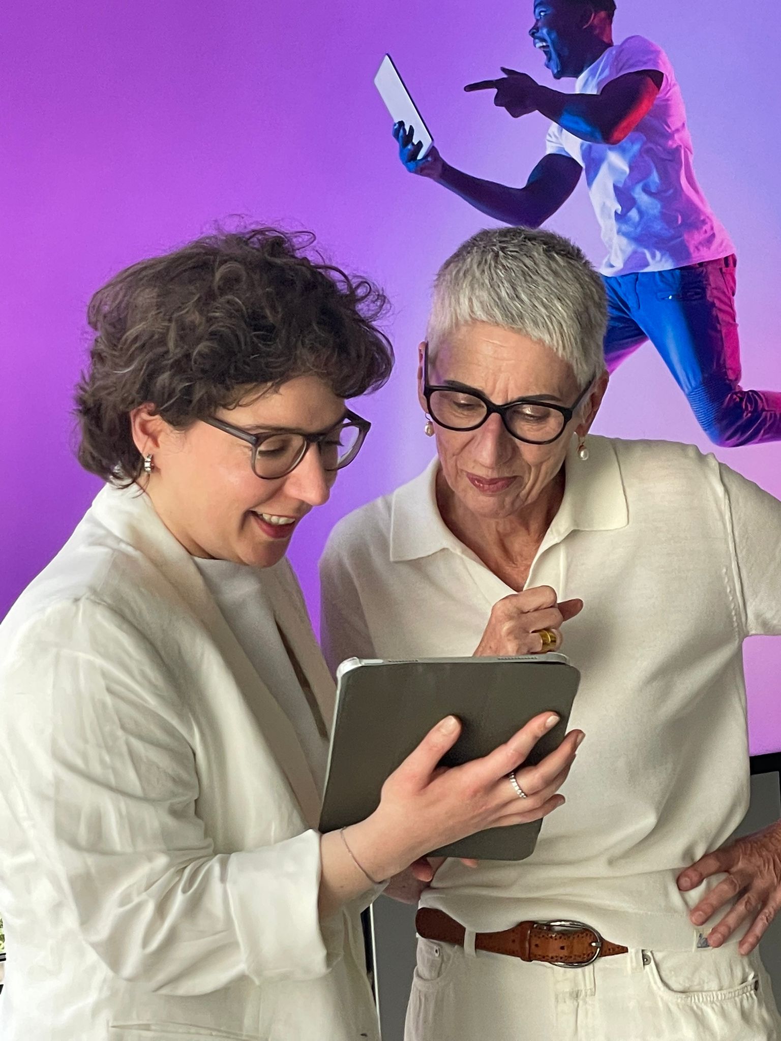 Zwei Frauen schauen auf ein Tablet.